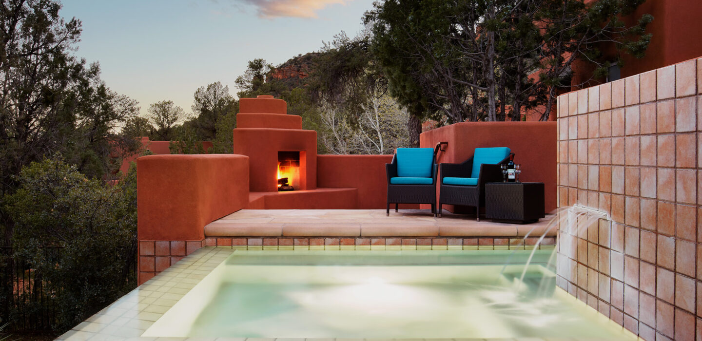 outdoor spa pool with fireplace glowing in the background