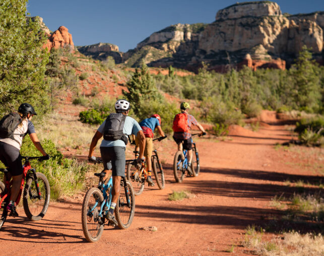 biker riders on red rock trail