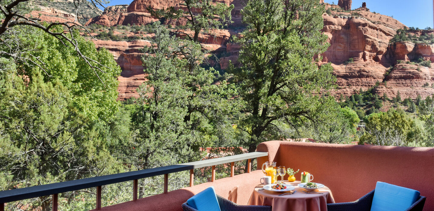 breakfast on patio table on a balcony with blue chairs