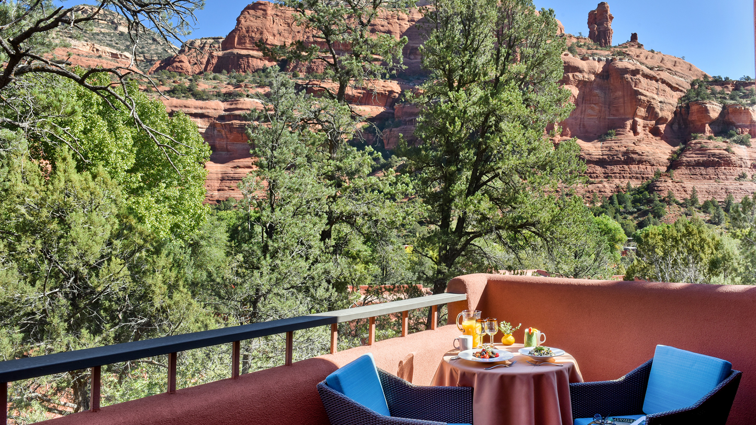 breakfast on patio table on a balcony with blue chairs