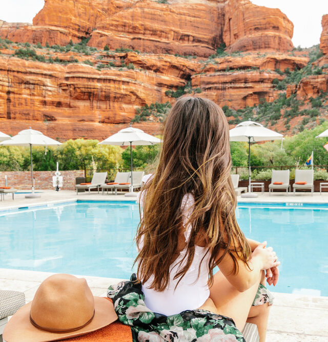 Pool with red rock view and woman looking out