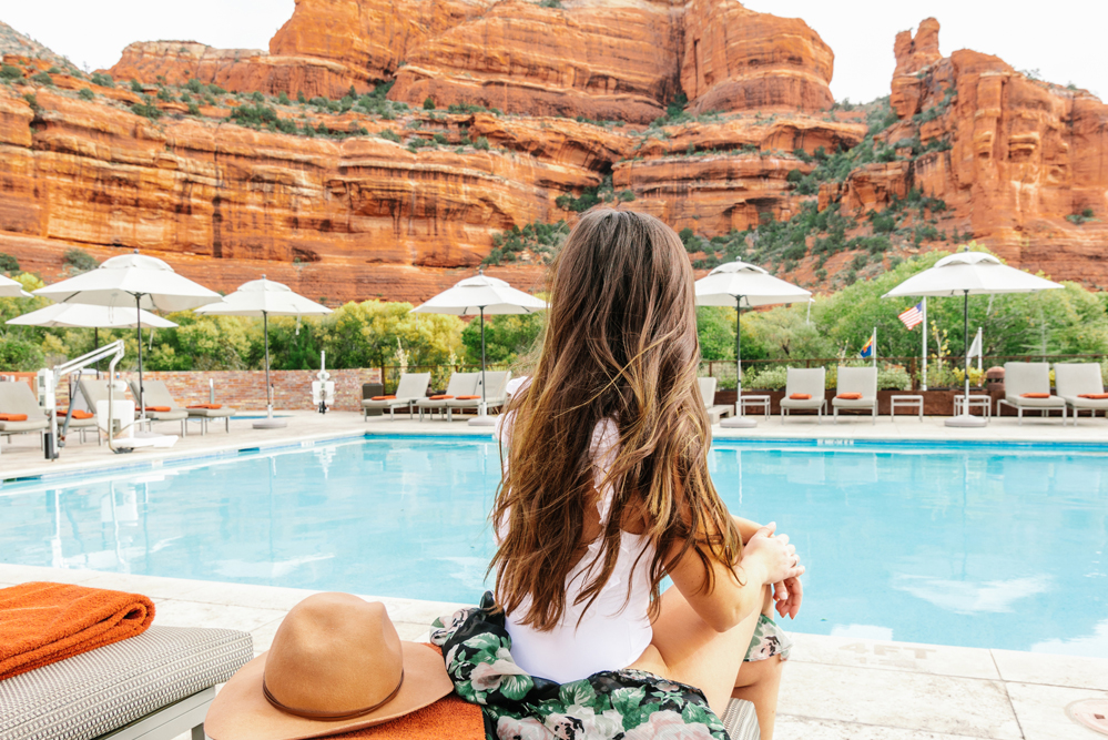 Pool with red rock view and woman looking out