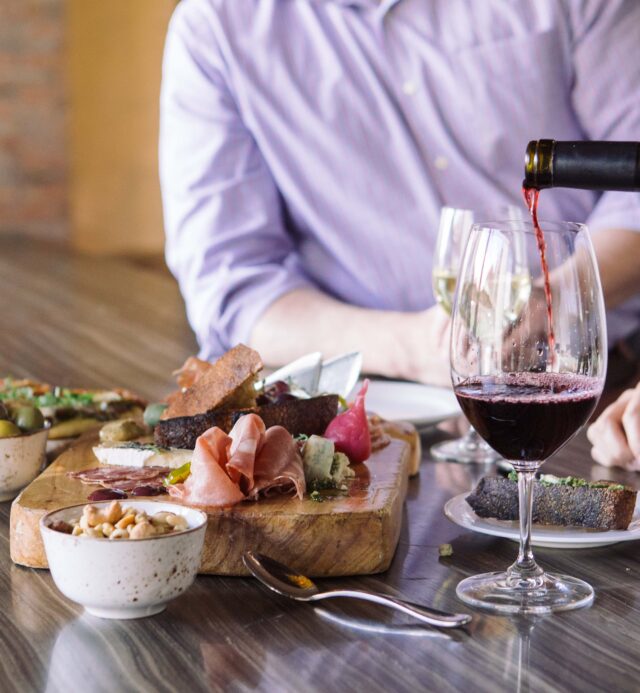 wine glass with cheese and olives on platter