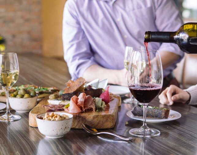 wine glass with cheese and olives on platter