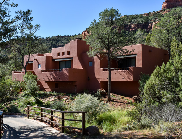clay colored hacienda with greenery in front