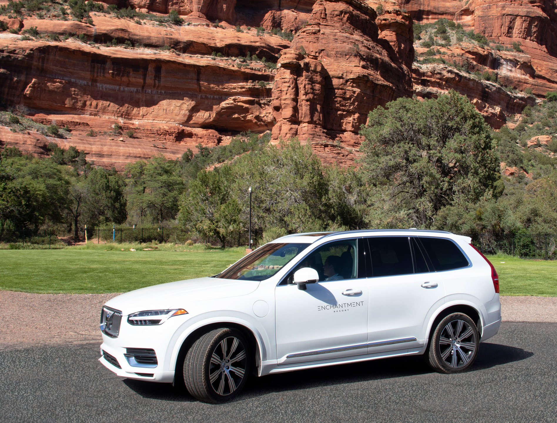 white volvo SUV with red rocks behind