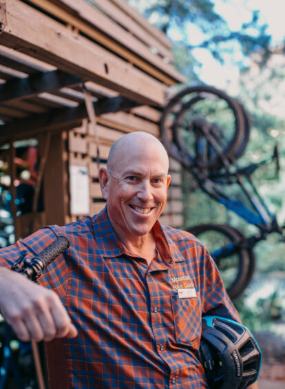 Man in plaid shirt holding bike helmet