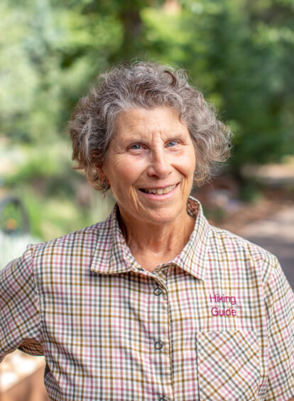 woman with curly hair wearing a checked collared shirt