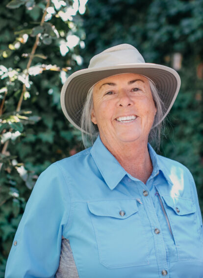 Woman with blue shirt and tan rimmed hat
