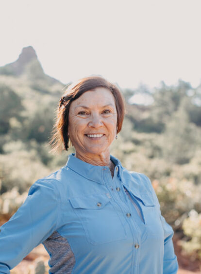 woman in blue dress shirt smiling