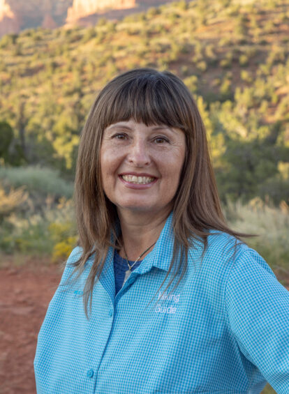 woman with long brown hair and blue collared shirt