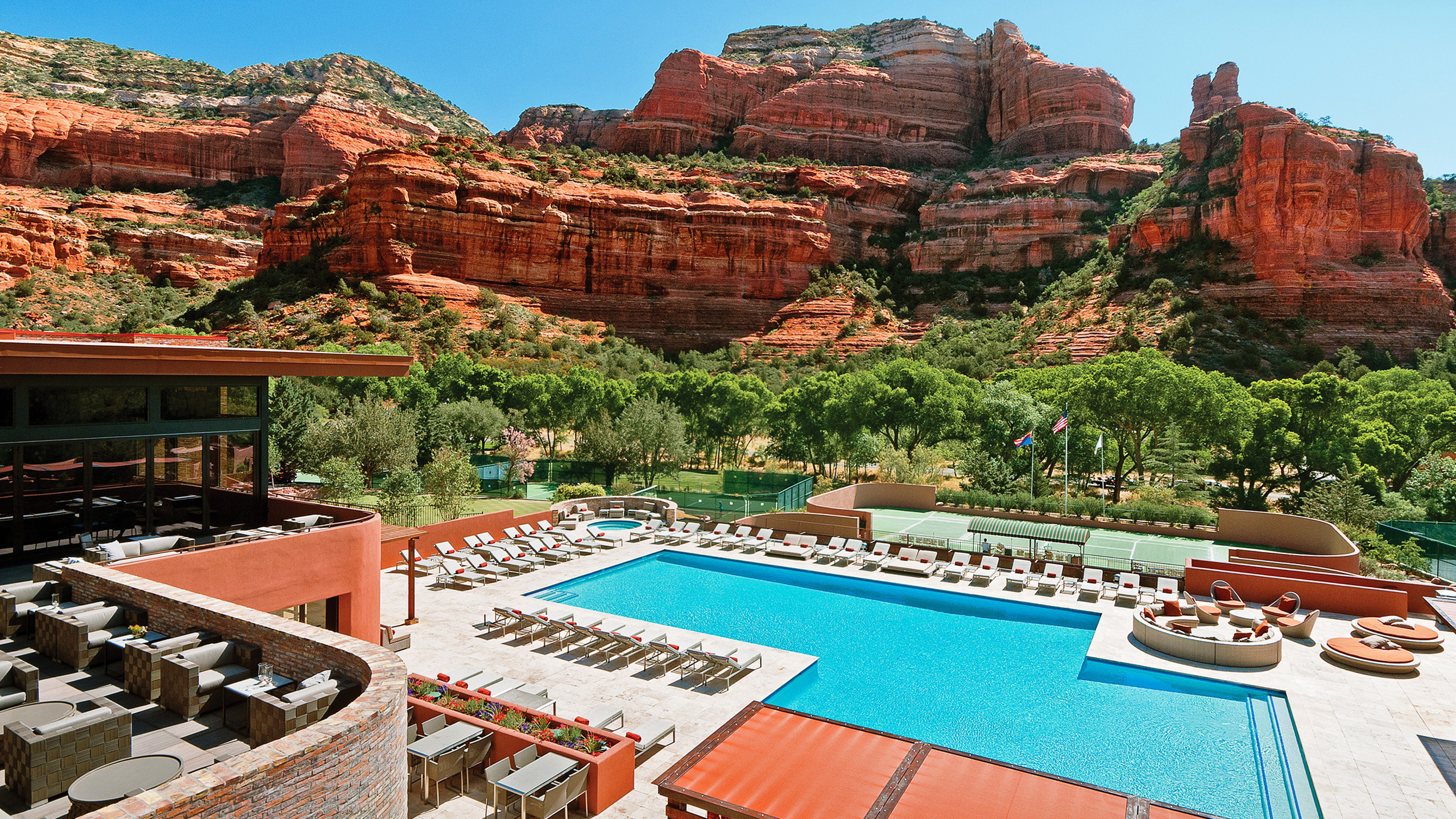 view of resort pool and tennis courts with red rock canyon in background