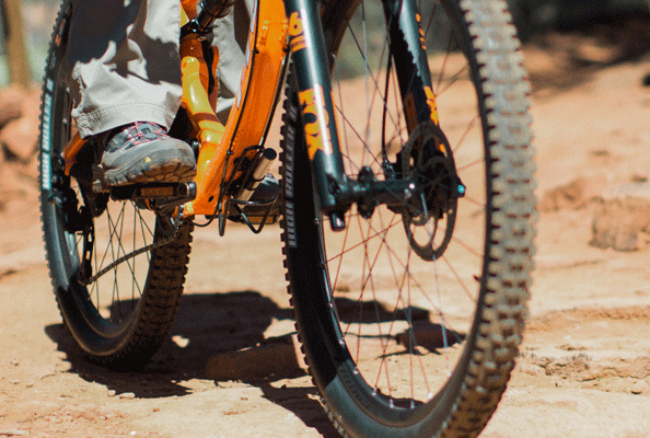 A close up image of the lower half of a bicycle being ridden