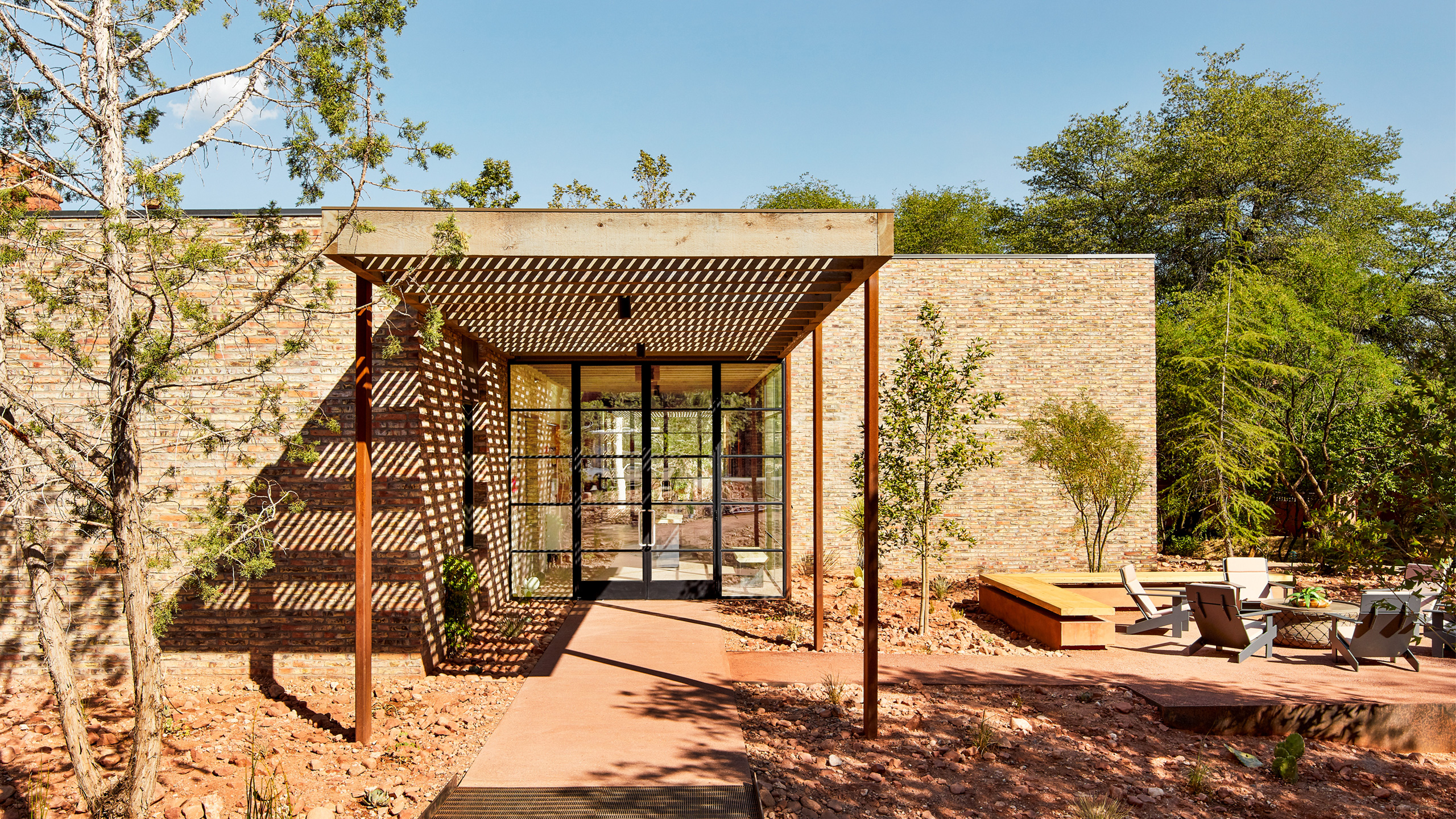 Entrance to Enchantment Trail House brick building with fire pit and chairs around