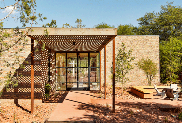 Entrance to Enchantment Trail House brick building with fire pit and chairs around