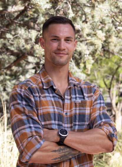 young man, brown hair, checkered shirt, posing with arms crossed