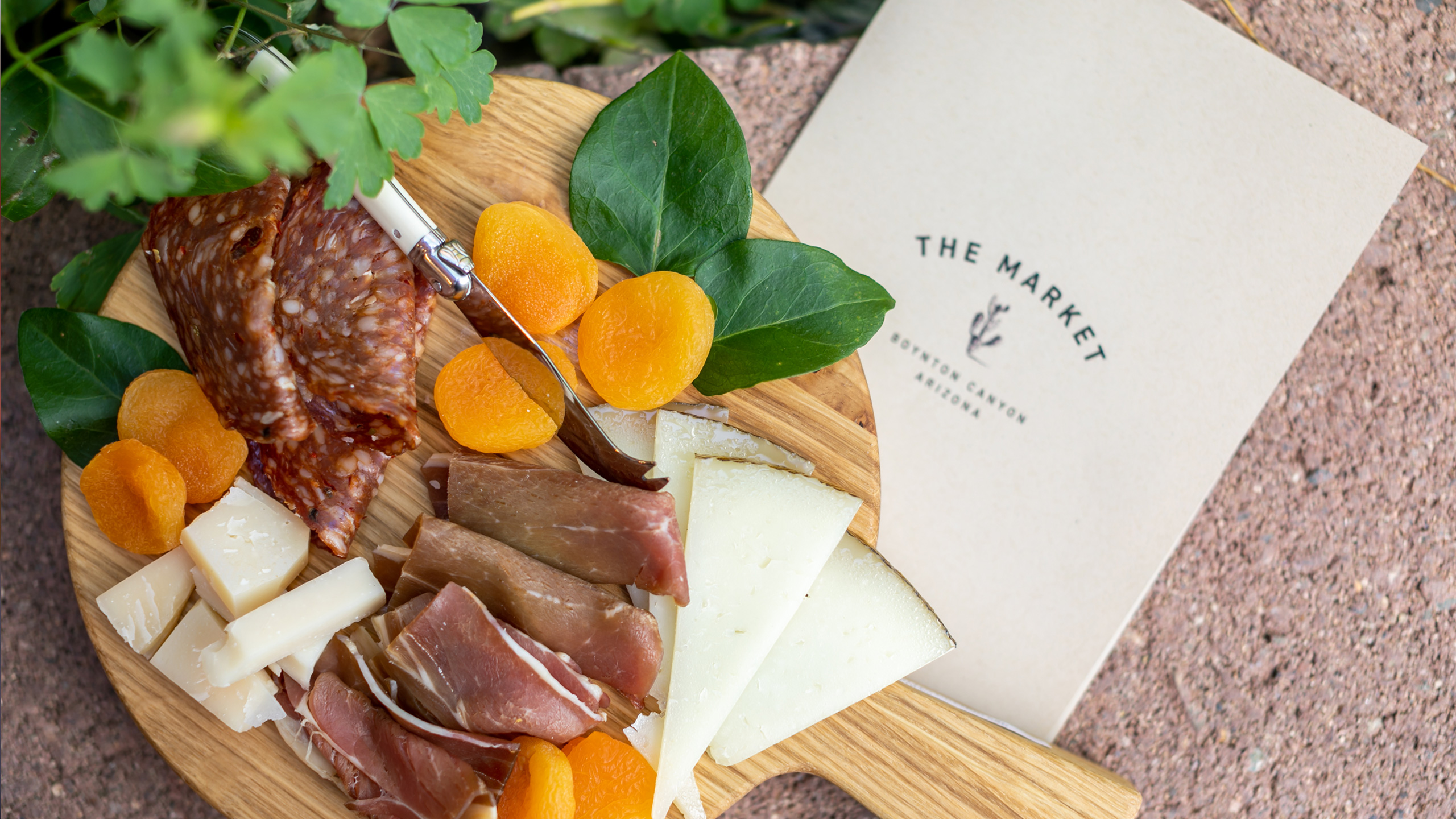 overhead view of charcuterie board with menu under it