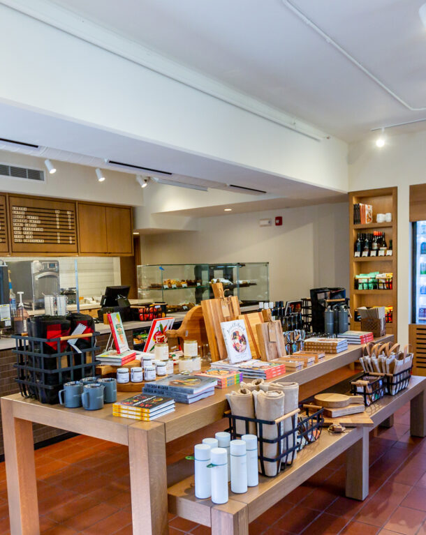 interior of coffee shop with retail table and beverage cooler filled with drinks