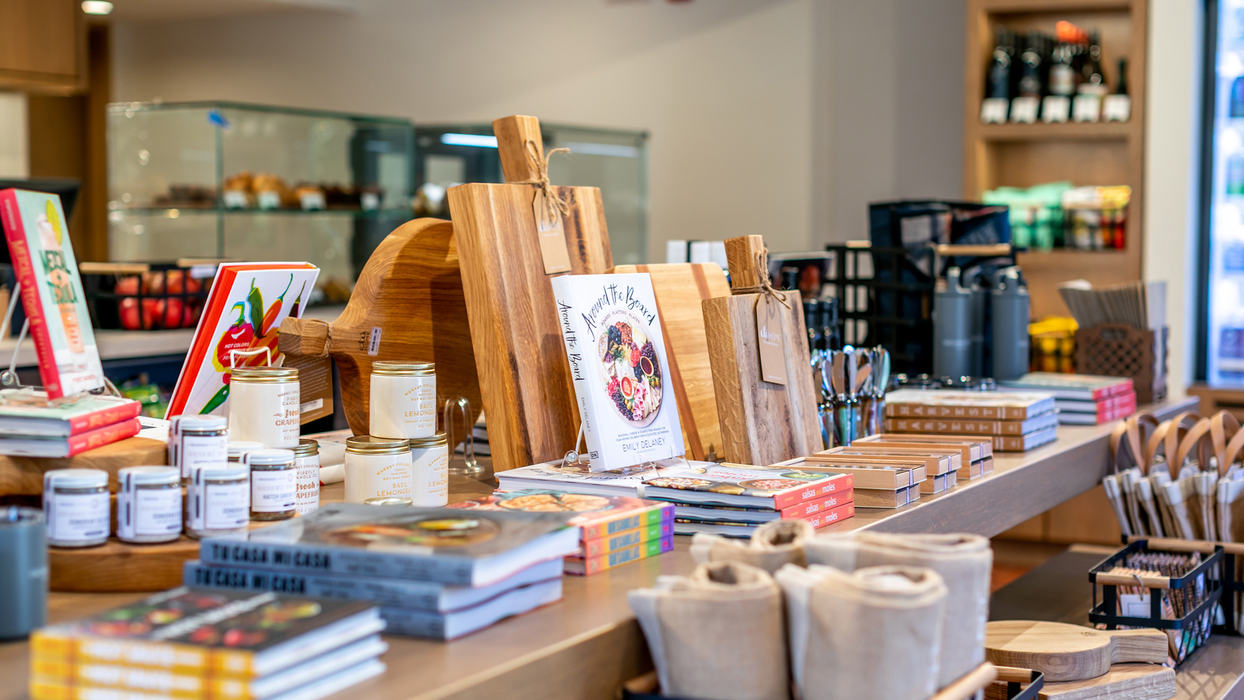 retail table with cutting boards, books, and jars of spices for sale