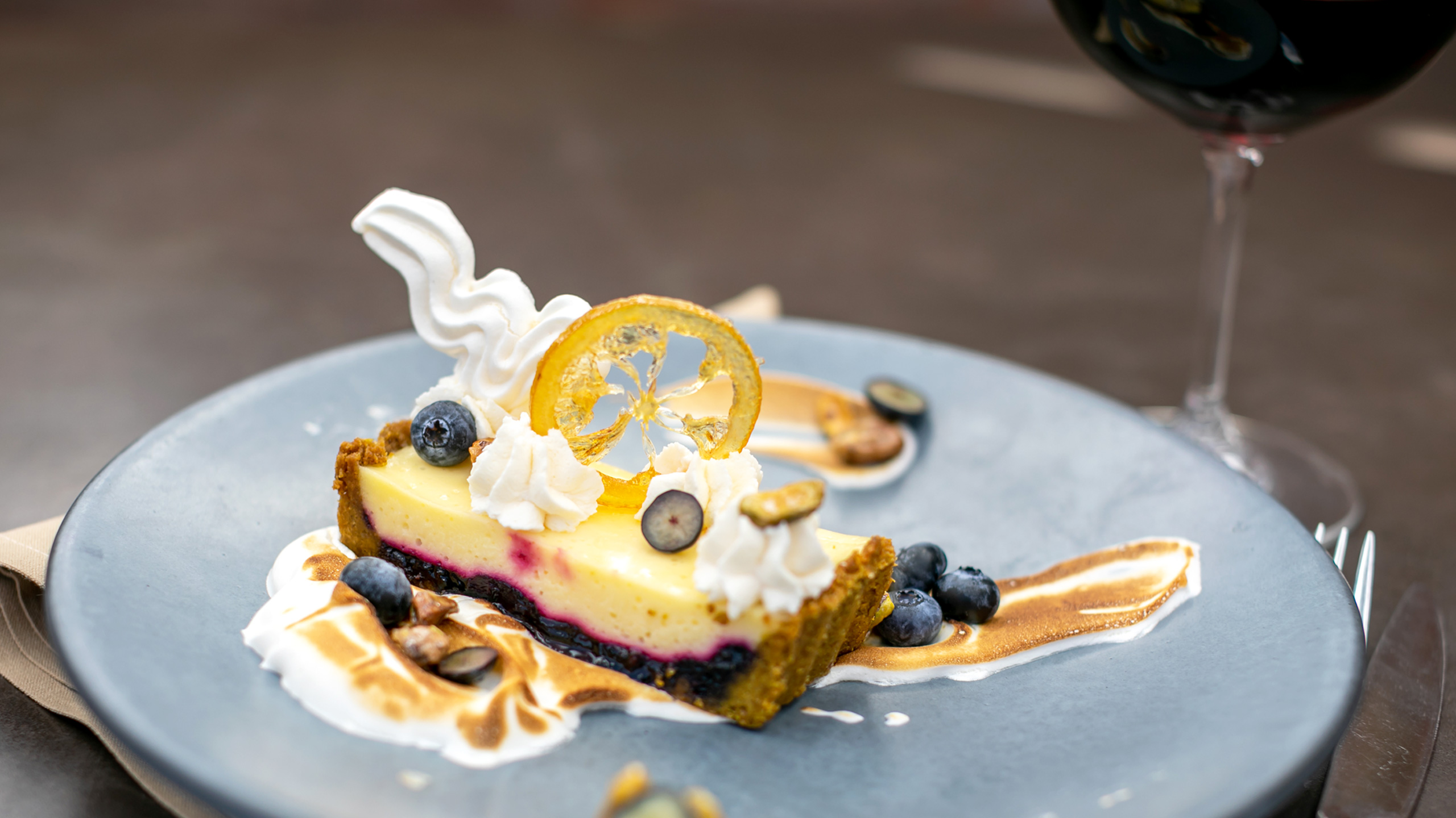 Lemon tart with blueberry layer and candied orange slice decoration