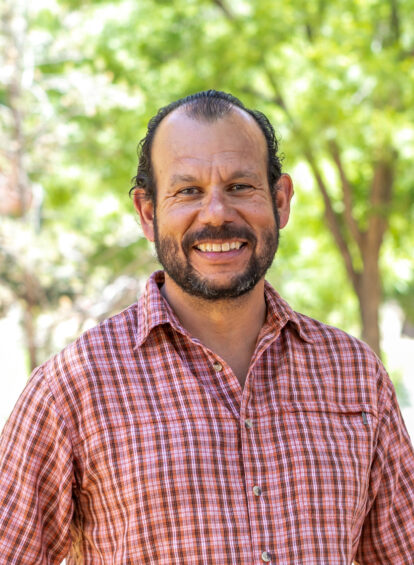 Gentleman wearing a plaid red shirt with the Sedona greenery in the background at Enchantment Resort