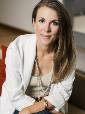 woman with long brown hair in white suit jacket