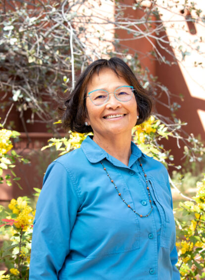 woman hiking guide in blue collared shirt and beaded necklace