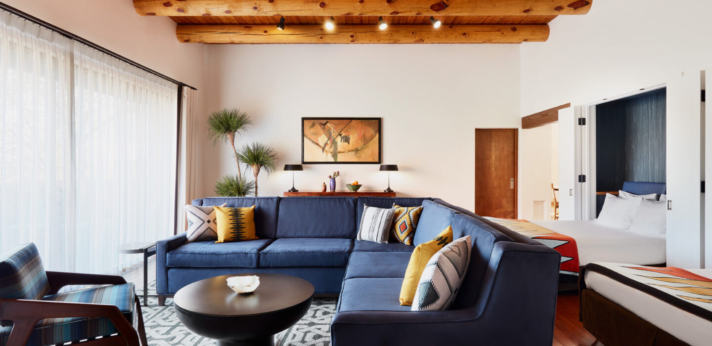 Hacienda 1 bedroom living room with blue couch and wood beam ceilings