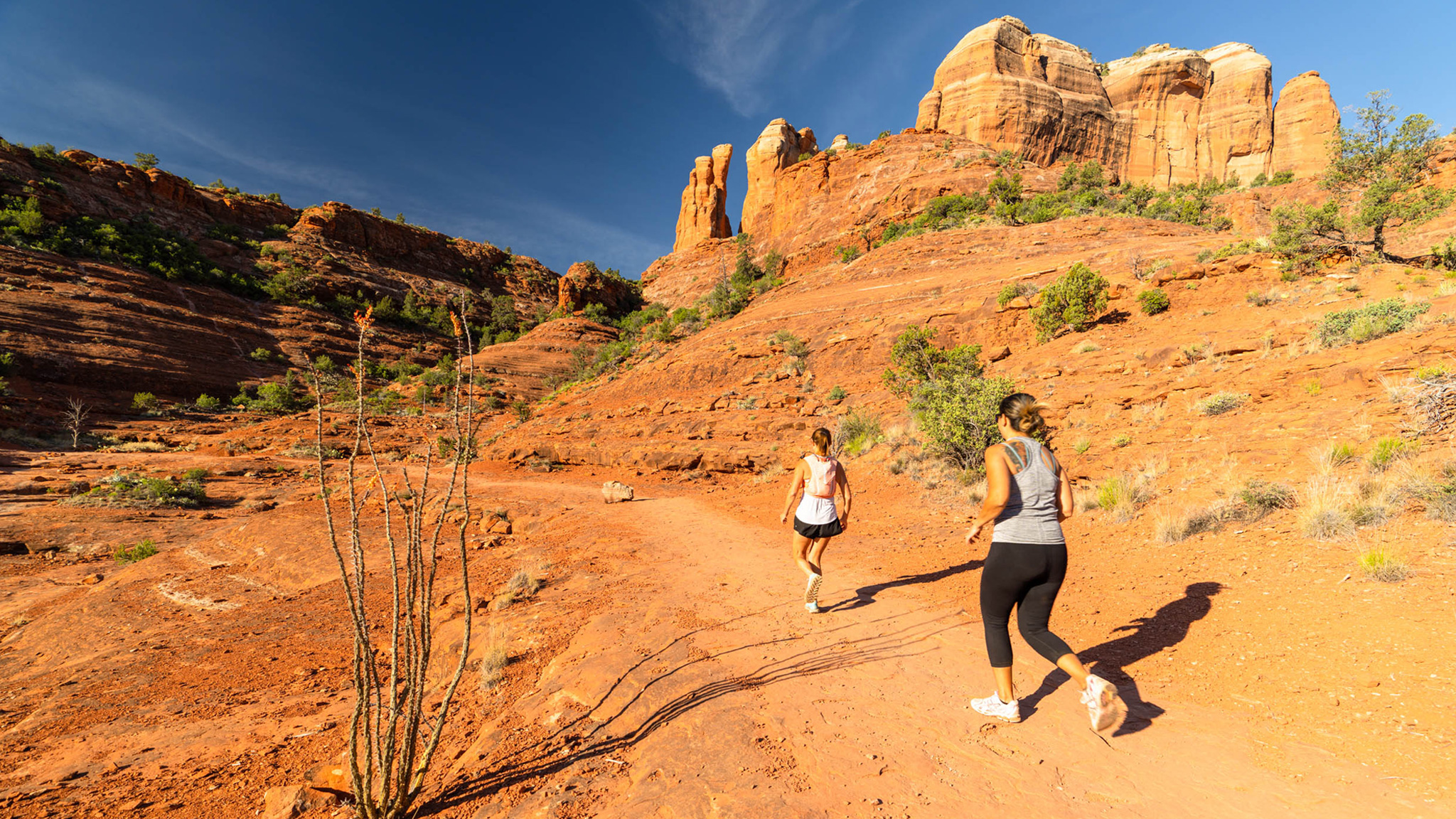 two runners on red rock trail