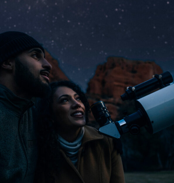 two guests looking into telescope during stargazing session in the winter at Enchantment