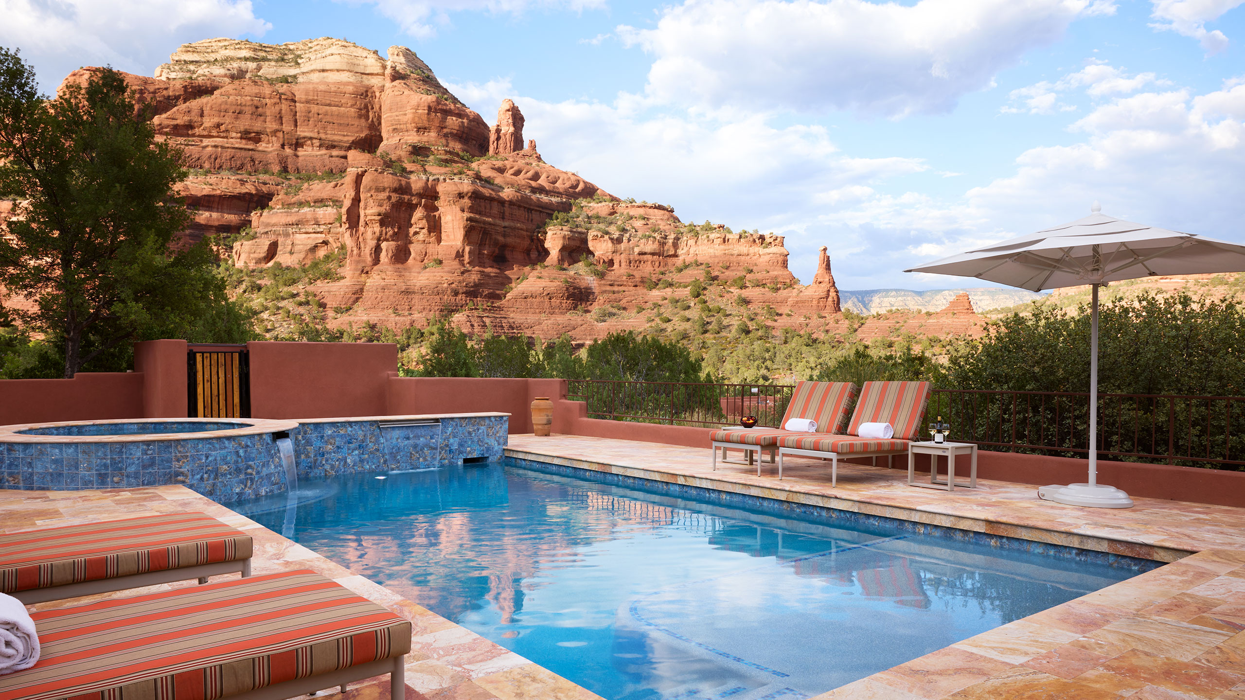 a pool with lounge chairs and an umbrella in the desert